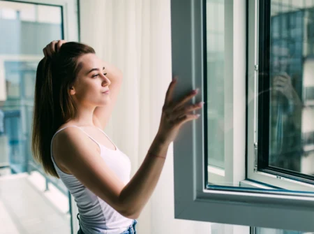 young woman opens plastic window