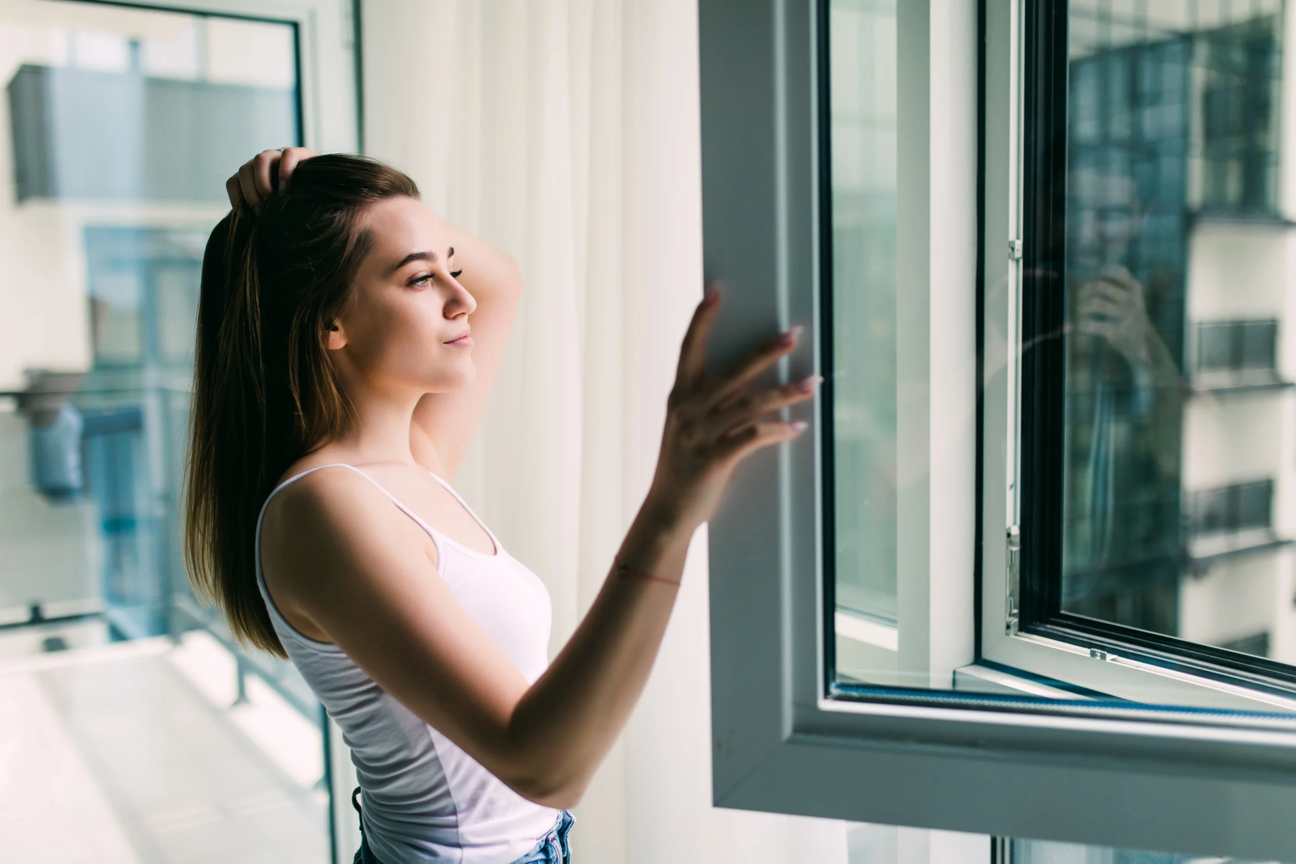 young woman opens plastic window